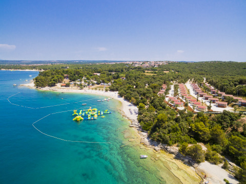 Aerial view of Camping Brioni holiday park in Istria, Croatia, with turquoise waters and lush greenery.