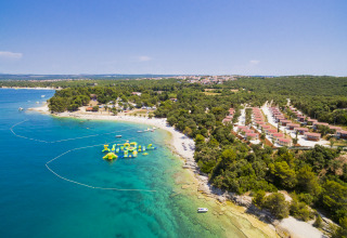 Luftaufnahme vom Camping Brioni Ferienpark in Istrien, Kroatien, mit klarem Meer und grüner Natur.