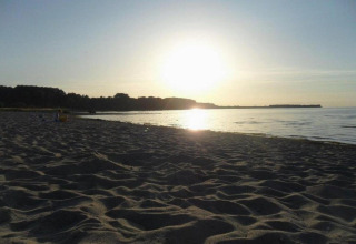 Strandzicht bij zonsondergang vanaf Bungalow complex ‘Gänseblümchen 6’ in Duitsland, serene sfeer.