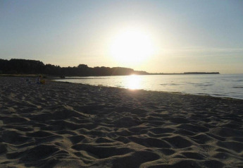 Strandzicht bij zonsondergang vanaf Bungalow complex ‘Gänseblümchen 6’ in Duitsland, serene sfeer.