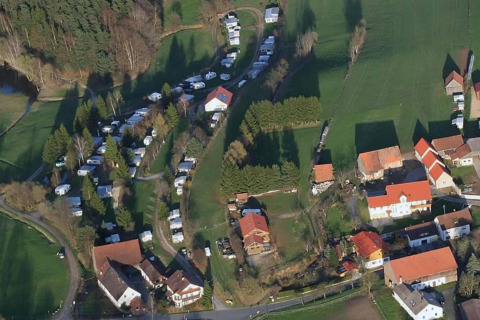 Aerial view of Holiday village SEEBLICK Tiny Chalet am Eixendorfer See, featuring cabins, trailers, and green fields.