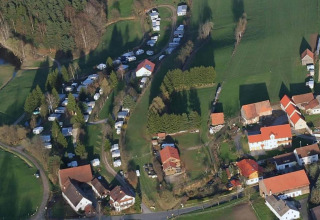 Vista aérea de Holiday village SEEBLICK Tiny Chalet am Eixendorfer See, con casas, caravanas y campos verdes.