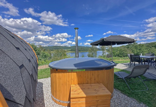 Casa pequeña y jacuzzi exterior con vistas a un lago en el Holiday village SEEBLICK, Alemania.