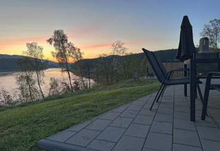 Udsigt over søen ved solnedgang fra terrassen i Holiday village SEEBLICK - Tiny Chalet am Eixendorfer See i Tyskland.