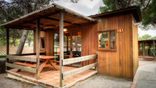 Gemütlicher Holzbungalow im Vilanova Park mit Veranda, Tisch und Bänken, Nummer 151.