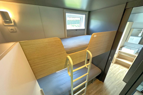 Moderne stapelbedden in een gezellig kamertje met houtdecor in SEEBLICK Tiny Chalet, Duitsland.