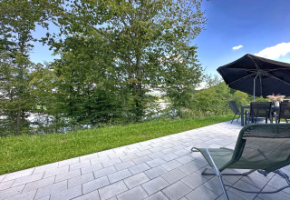 Udsigt fra terrasse i Holiday village SEEBLICK, Tiny Chalet am Eixendorfer See med skov og sø i Tyskland.