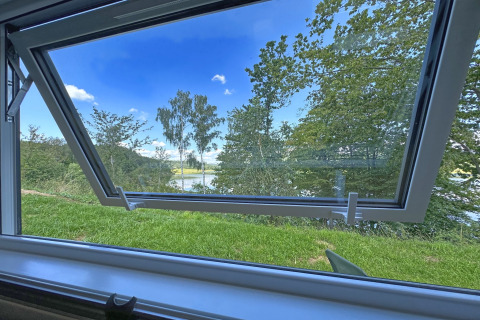 Uitzicht vanuit een open raam bij Holiday village SEEBLICK - Tiny Chalet am Eixendorfer See in Duitsland.