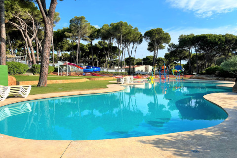 Udendørs swimmingpool ved CAMPING INTERPALS- Bungalow Sa Riera i Spanien, med rutschebaner og solsenge.