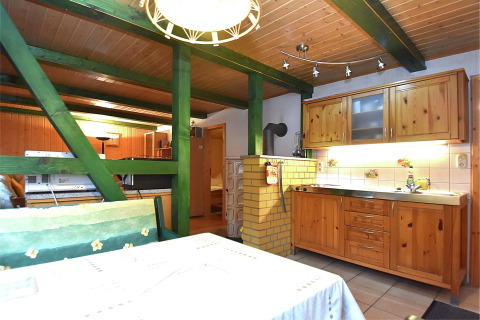 Houten keuken en eetgedeelte met groene balken in een gezellige lodge in Neustadt, Duitsland.