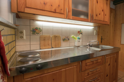 Gezellige keuken in lodge Neustadt in Duitsland met houten kasten, elektrische kookplaat en spoelbak.