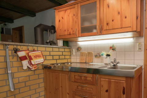 Gezellige keukenhoek in een lodge in Neustadt, Duitsland, met houten kasten en rustieke tegels.