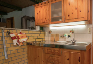 Gezellige keukenhoek in een lodge in Neustadt, Duitsland, met houten kasten en rustieke tegels.