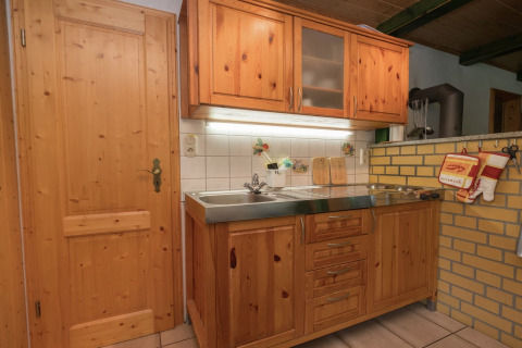 Gezellige keuken met houten kasten, spoelbak en kookplaat in lodge Neustadt in Duitsland.