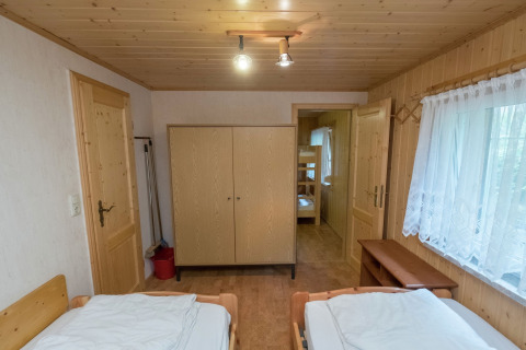 Gezellige houten kamer met twee bedden, kast en stapelbed in lodge Neustadt in Duitsland, ruim raam.