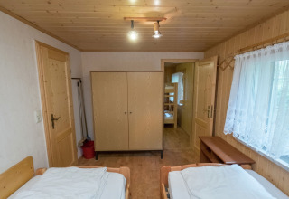 Gezellige houten kamer met twee bedden, kast en stapelbed in lodge Neustadt in Duitsland, ruim raam.