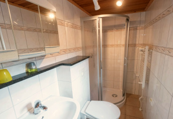 Modern bathroom with shower, sink, and toilet at Lodge Neustadt, Germany, featuring tiled walls.