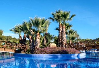 Palmiers et ponts en bois sur îlot dans la piscine du Camping Estival Torre de la Mora COCO TENT 4 Pax en Espagne.