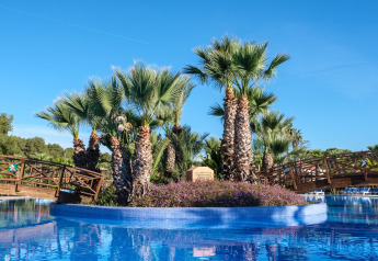 Palmeninsel mit Holzbrücke in Pool bei Camping Estival Torre de la Mora COCO TENT 4 Pax in Spanien.