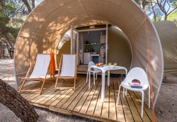 Außenterrasse eines Safarizeltes mit Stühlen, Tisch und Frühstück im Camping Estival Torre de la Mora, Spanien.