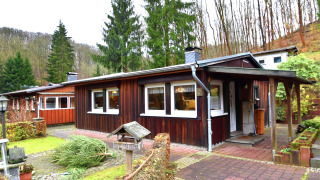 Casa vacanze Holiday home with Parking, esterno in legno, circondata da alberi e prato verde in inverno.