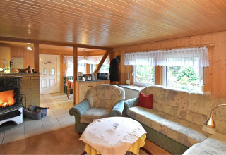Gemütliches Wohnzimmer im Ferienhaus 'mit Parkplatz' in Deutschland mit Kamin und Sofas.