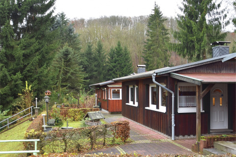 Træhytte ved Holiday home «with Parking» i Tyskland, omgivet af grantræer og en velplejet have.