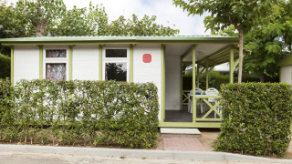 Udendørs billede af Camping Cambrils Playa 1 BUNGALOW OASIS med grønne kanter og terrasseområde.