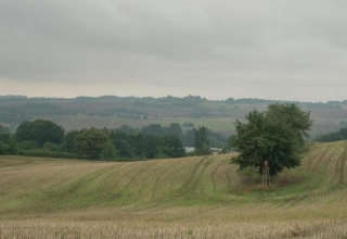 Vista su campi e colline con alberi sotto un cielo nuvoloso vicino a Holiday home 'with Parking' in Germania.