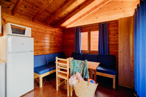 Interno della cabina La Llosa 3 LLEBEIG in Spagna con cucina, tavolo da pranzo e tende blu.