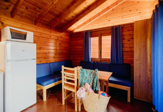 Interno della cabina La Llosa 3 LLEBEIG in Spagna con cucina, tavolo da pranzo e tende blu.