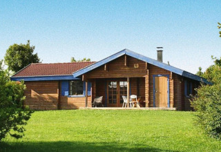 Chalet in legno nel parco vacanze Lauterdörfle, Tipo A Lauter, per 4 persone, prato verde e dettagli blu.