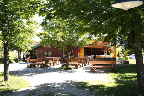 Buiten zitten met houten banken bij chalet Holiday park Lauterdörfle, omringd door bomen in Duitsland.