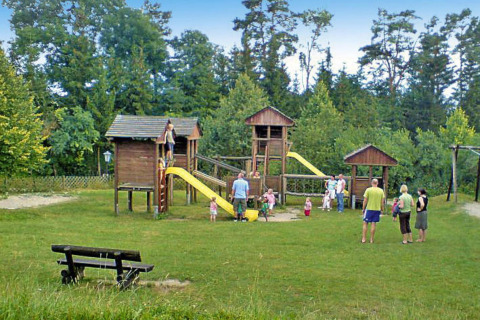 Kinderen en volwassenen spelen op een houten speeltuin aan Holiday park Lauterdörfle in Duitsland.