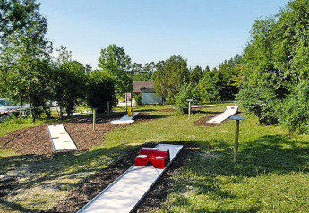 Outdoor mini golf course at Holiday park Lauterdörfle in Germany, surrounded by greenery and clear skies.