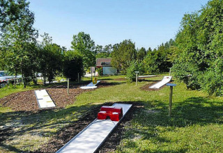 Buiten minigolfbaan bij Holiday park Lauterdörfle in Duitsland, omgeven door bomen en natuurlijke omgeving.