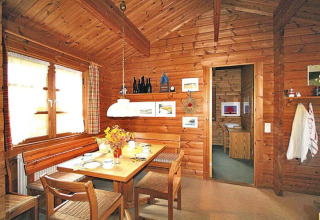Foto de un acogedor comedor en un chalet de madera, con mesa puesta y decoraciones rústicas.