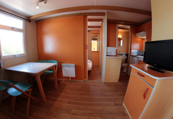 Interior view of Camping Rocagrossa Bungalow for four people in Spain, featuring kitchen and dining area.