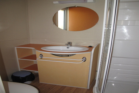 Badeværelse i Camping Rocagrossa Bungalow for 4 personer i Spanien, med vask, spejl og bruseniche.