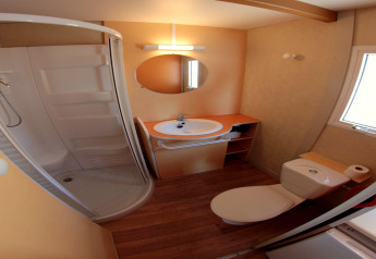 Badezimmer im Camping Rocagrossa Bungalow für 4 Personen in Spanien mit Dusche, WC und Waschbecken.