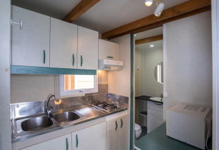 Kompakt køkken og badeværelse i Camping Rocagrossa Bungalow til 5 personer i Spanien, moderne faciliteter.