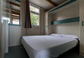 Schlafzimmer mit Doppelbett und modernem Design im Camping Rocagrossa Bungalow für 5 Personen in Spanien.
