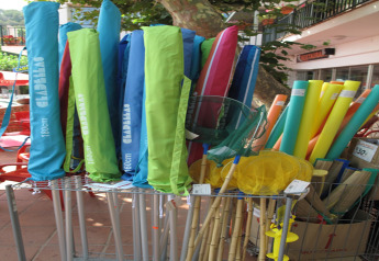 Variedad de accesorios de playa coloridos como sillas, redes y churros en un alojamiento glamping.