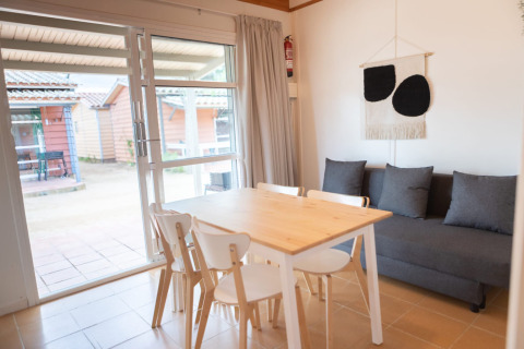 Eethoek in Camping del Mar BUNGALOW MEDITERRANI met tafel, stoelen en bank in Spanje.
