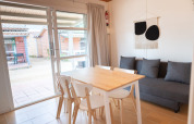 Bright dining area at Camping del Mar BUNGALOW MEDITERRANI with table, chairs and sofa in Spain.