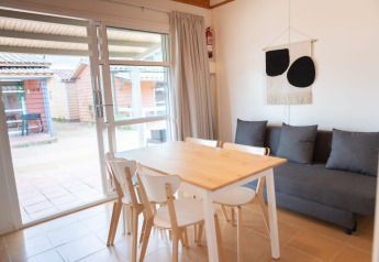 Bright dining area at Camping del Mar BUNGALOW MEDITERRANI with table, chairs and sofa in Spain.