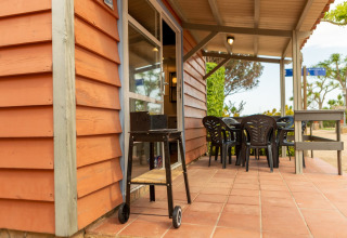 Buitenpatio bij Camping del Mar BUNGALOW MEDITERRANI in Spanje met barbecue, tafel en stoelen.