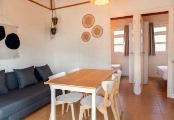 Helles Wohnzimmer mit Esstisch und Sofa im Camping del Mar BUNGALOW MEDITERRANI in Spanien.