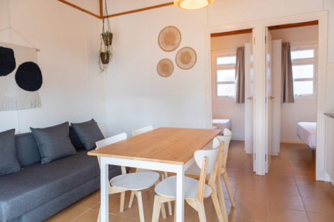 Heldere en gezellige woonkamer met eettafel en bank bij Camping del Mar BUNGALOW MEDITERRANI in Spanje.