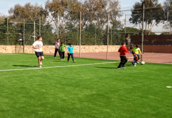 Kinder und Erwachsene spielen Fußball auf einem grünen Feld bei Camping del Mar BUNGALOW MEDITERRANI in Spanien.